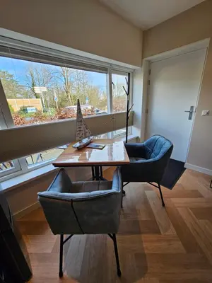 a room with a table and chairs and a large window at Bed and Beach in Schoorl in Schoorl