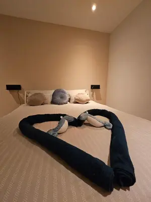 a person laying on a bed in a room at Bed and Beach in Schoorl in Schoorl