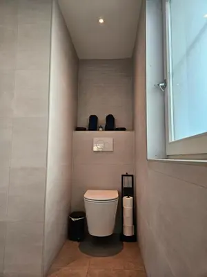 a small bathroom with a toilet and a window at Bed and Beach in Schoorl in Schoorl