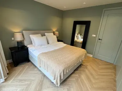 a bedroom with a large bed and a mirror at Luxurious, spacious appartment in Amsterdam