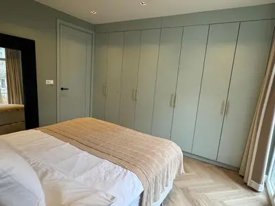 a bedroom with a bed with white cabinets at Luxurious, spacious appartment in Amsterdam