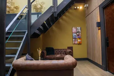 a living room with a couch and a staircase at Manzo's Suites in Zaandam