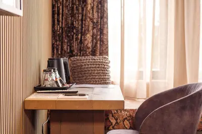 a desk with two chairs next to a window at Manzo's Suites in Zaandam