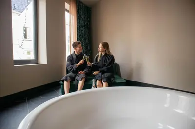 a man and woman sitting in a chair in a room at Manzo's Suites in Zaandam