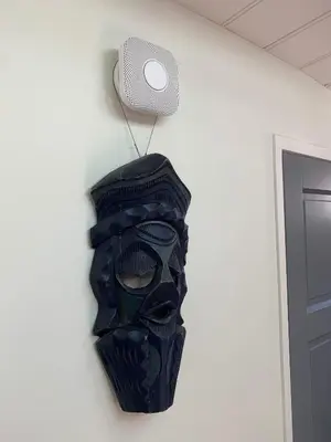 a mask hanging on a wall with a speaker at Appartement op woonboot hartje centrum in Amsterdam