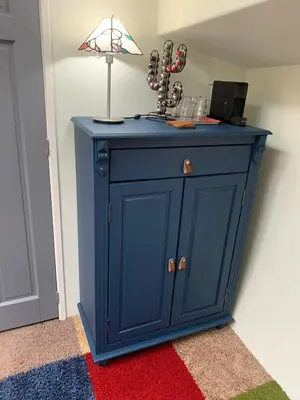 a blue cabinet with a lamp on top on a rug at Appartement op woonboot hartje centrum in Amsterdam