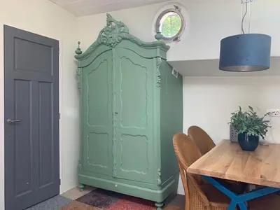 a green cabinet in a room with a table at Appartement op woonboot hartje centrum in Amsterdam