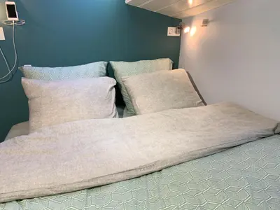 a bed with two pillows on it in a room at Appartement op woonboot hartje centrum in Amsterdam