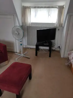 a living room with a piano and a window at Zit slaapkamer op de 2e etage in een rietgedekte villa met gedeelde douche en keuken in Wassenaar