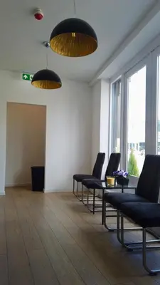 a waiting room with chairs and a table and windows at Y Hostel in Amsterdam