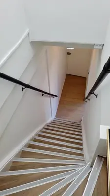 a staircase in a building with white walls and wooden floors at Y Hostel in Amsterdam