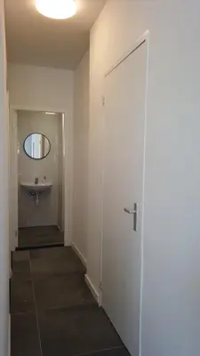 a bathroom with a sink and a door with a mirror at Y Hostel in Amsterdam