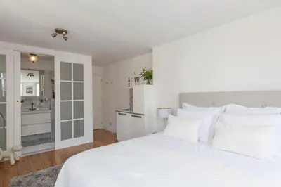 a white bedroom with a large white bed with white pillows at Jordaan Suite bed and bubbles in Amsterdam