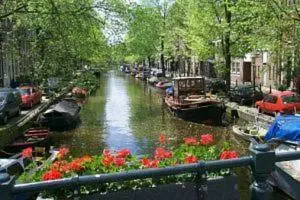 a canal with boats and flowers on the side at Jordaan Suite bed and bubbles in Amsterdam
