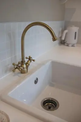 a white sink with a gold faucet on it at B&B La Balena in Zaandijk near Amsterdam in Zaandijk