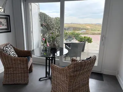 a dining room with a table and chairs and a window at Studio Sunrise in Zandvoort
