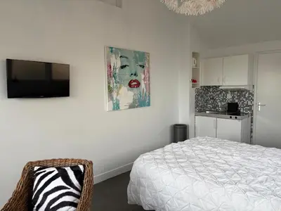 a bedroom with a bed and a television on a wall at Studio Sunrise in Zandvoort
