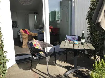 a patio with a table and chairs and a bottle of wine at Studio Sunrise in Zandvoort