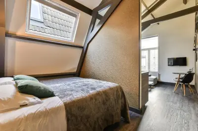 a bedroom with a bed and a window at Loft Studio's in Zandvoort
