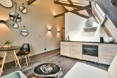 a kitchen with white walls and wooden floors and a table at Loft Studio's in Zandvoort