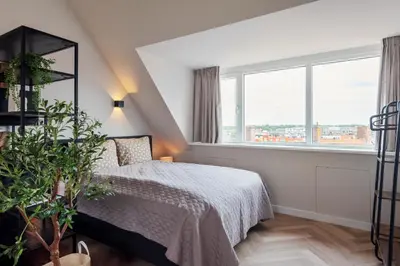 a bedroom with a bed and a large window at Short Stay Zandvoort at 68 in Zandvoort