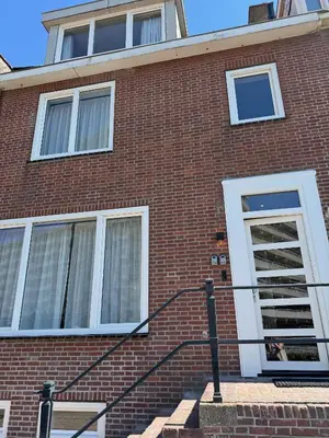 a red brick building with a person in a window at Short Stay Zandvoort at 68 in Zandvoort