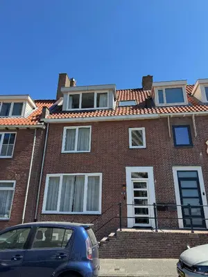 a brick house with a car parked in front of it at Short Stay Zandvoort at 68 in Zandvoort