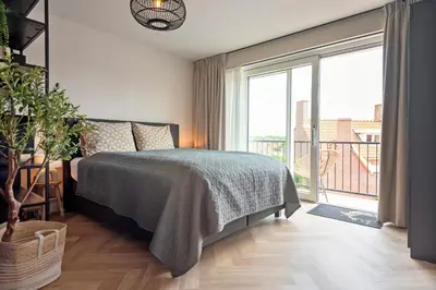 a bedroom with a bed and a large window at Short Stay Zandvoort at 68 in Zandvoort