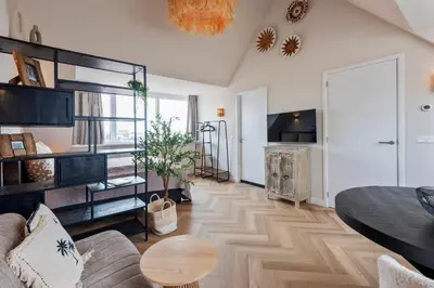 a living room with a bed and a table at Short Stay Zandvoort at 68 in Zandvoort