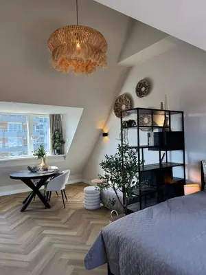 a bedroom with a bed and a table and a chandelier at Short Stay Zandvoort at 68 in Zandvoort