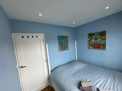 a bedroom with blue walls and a bed with a door at Amsterdam lake area, super wifi island incl boat in Vinkeveen