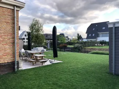 a patio with a table and chairs in a yard at House with garden in Amsterdam in Weesp