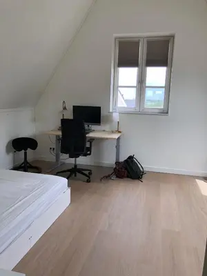 a bedroom with a bed and a desk with a computer at House with garden in Amsterdam in Weesp