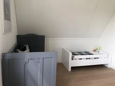 a room with a bed and a crib in a room at House with garden in Amsterdam in Weesp