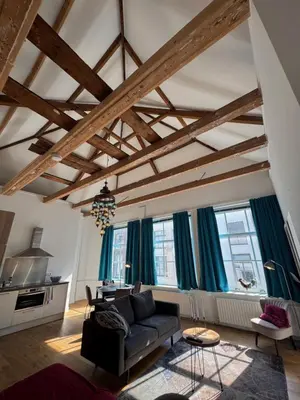 a living room with a couch and some windows at Barbera Guesthouse Hotel Apartments - Experience local life in the Old Centre in Haarlem