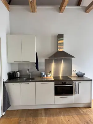a kitchen with white cabinets and a stove at Barbera Guesthouse Hotel Apartments - Experience local life in the Old Centre in Haarlem