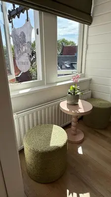 a room with two stools and a table and a window at De Toerist Thuis Bij De Sluis in Spaarndam