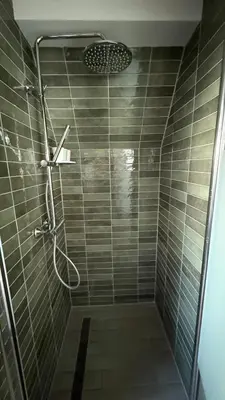 a shower with a shower head in a bathroom at De Toerist Thuis Bij De Sluis in Spaarndam