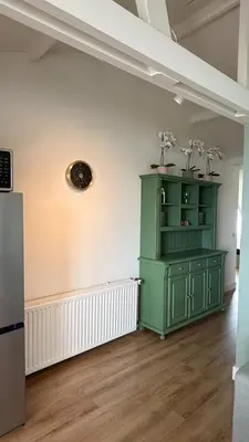 a green cabinet in the corner of a room at De Toerist Thuis Bij De Sluis in Spaarndam