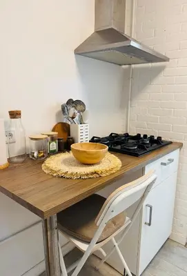 a kitchen counter with a wooden table with a bowl on it at tiny beach house noordwijk in Noordwijk aan Zee
