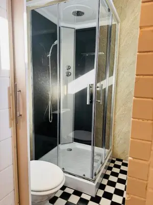a glass shower in a bathroom with a toilet at tiny beach house noordwijk in Noordwijk aan Zee