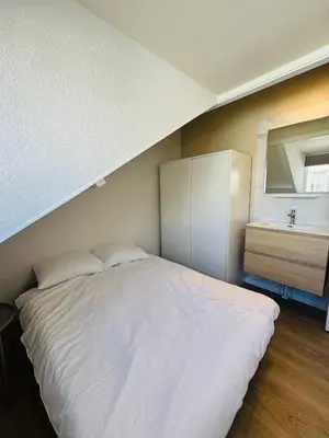 a bedroom with a large white bed and a sink at familie huisje de kleine schelp in Noordwijk aan Zee