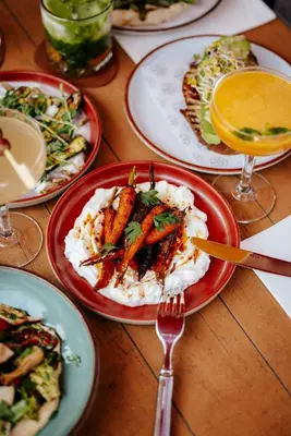 a wooden table with plates of food on it at The Social Hub Amsterdam City Extended Stay in Amsterdam