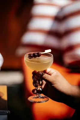 a person holding a drink with a cigarette in it at The Social Hub Amsterdam City Extended Stay in Amsterdam