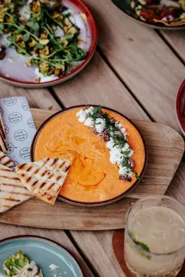 a table with a plate of food on a wooden table at The Social Hub Amsterdam City Extended Stay in Amsterdam