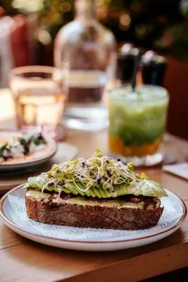 a sandwich on a white plate on a table at The Social Hub Amsterdam City Extended Stay in Amsterdam