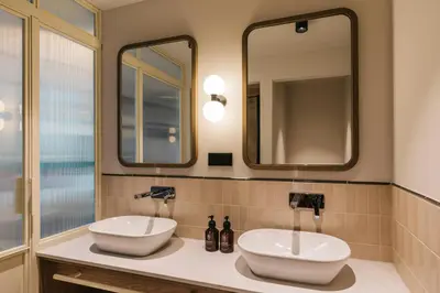 two sinks in a bathroom with two mirrors at The Social Hub Amsterdam City Extended Stay in Amsterdam