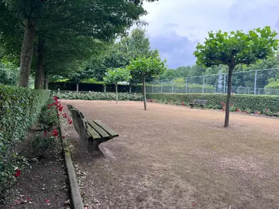 a park with two benches and flowers and a fence at Villa NovaTerra - Zeewolde in Zeewolde