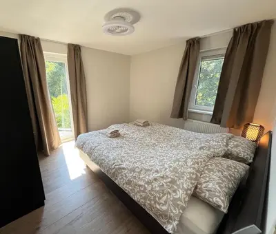 a bedroom with a bed and two windows at Villa NovaTerra - Zeewolde in Zeewolde