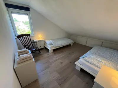 a room with two beds and a desk and a window at Villa NovaTerra - Zeewolde in Zeewolde